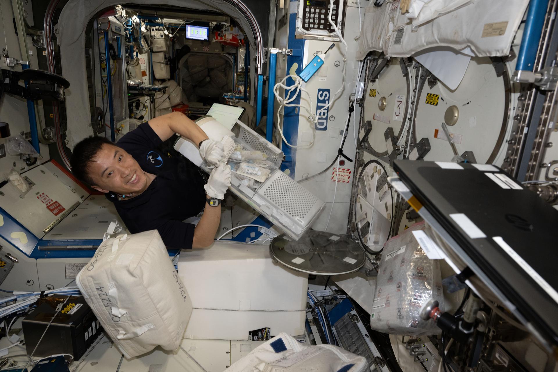 Astronauta Jonny Kim armazenando amostras de pesquisa na Estação Espacial Internacional